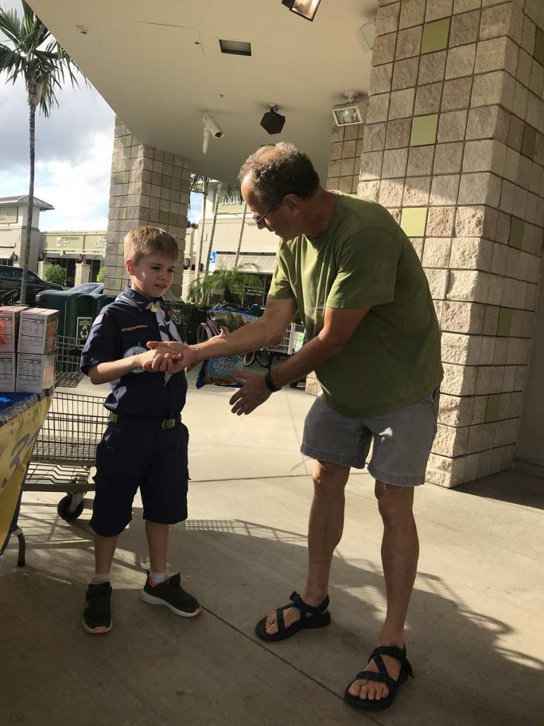 Liam Crawford(8), of Cub Scout Pack 333 in Boca,seals the deal with a hand shake.